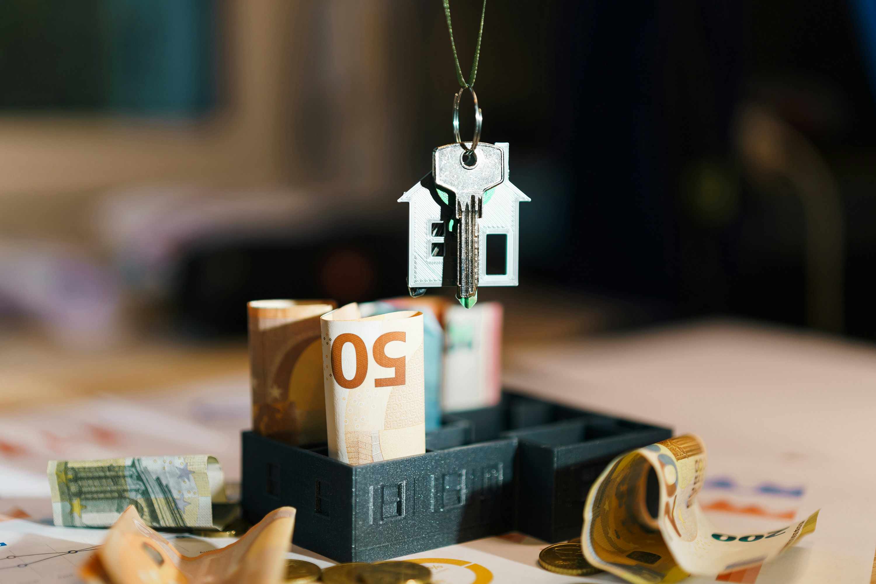 Sicherheitsorientierte Baufinanzierungsberatung mit Taschenrechner, Finanzierungsplan und Immobilienexposé für ein Haus in Baden-Württemberg.